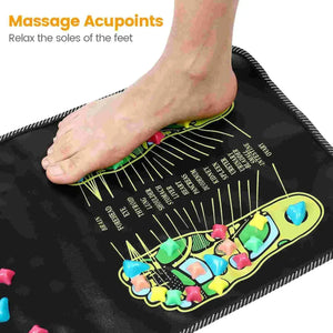 Bare foot standing on pebble stones of the reflexology mat