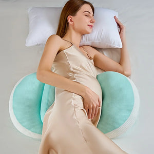 Pregnant woman lying on her side with green butterfly maternity pillow