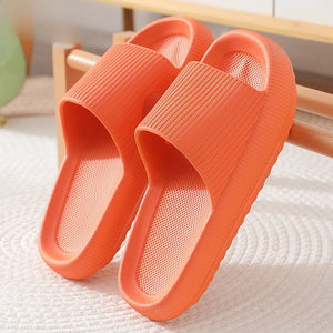 Pair of orange cloud slippers with thick cushioned sole