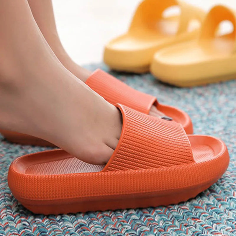 Woman wearing orange cloud slippers on a rug